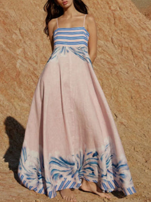 Pink maxi dress with spaghetti straps, blue stripes on bustier, and abstract blue print on skirt.