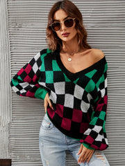 Geometric knit sweater with V-neck, puff sleeves, and checkerboard pattern in black, green, white, and maroon.