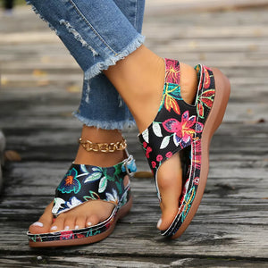 Embroidered floral thong wedge sandals with adjustable ankle strap and comfortable sole.