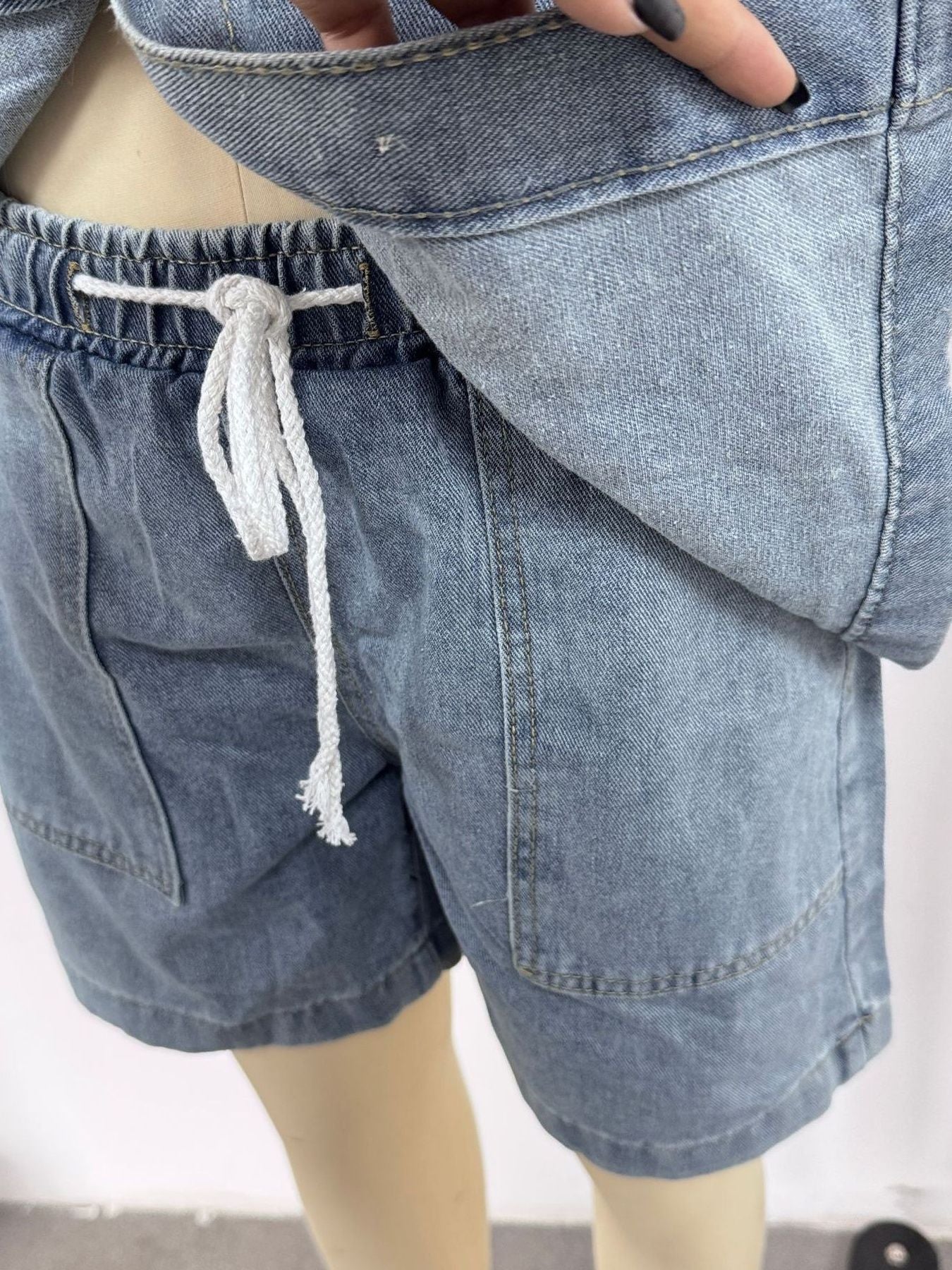 Button-up denim shorts set in sky blue with drawstring waist and collared top detail.