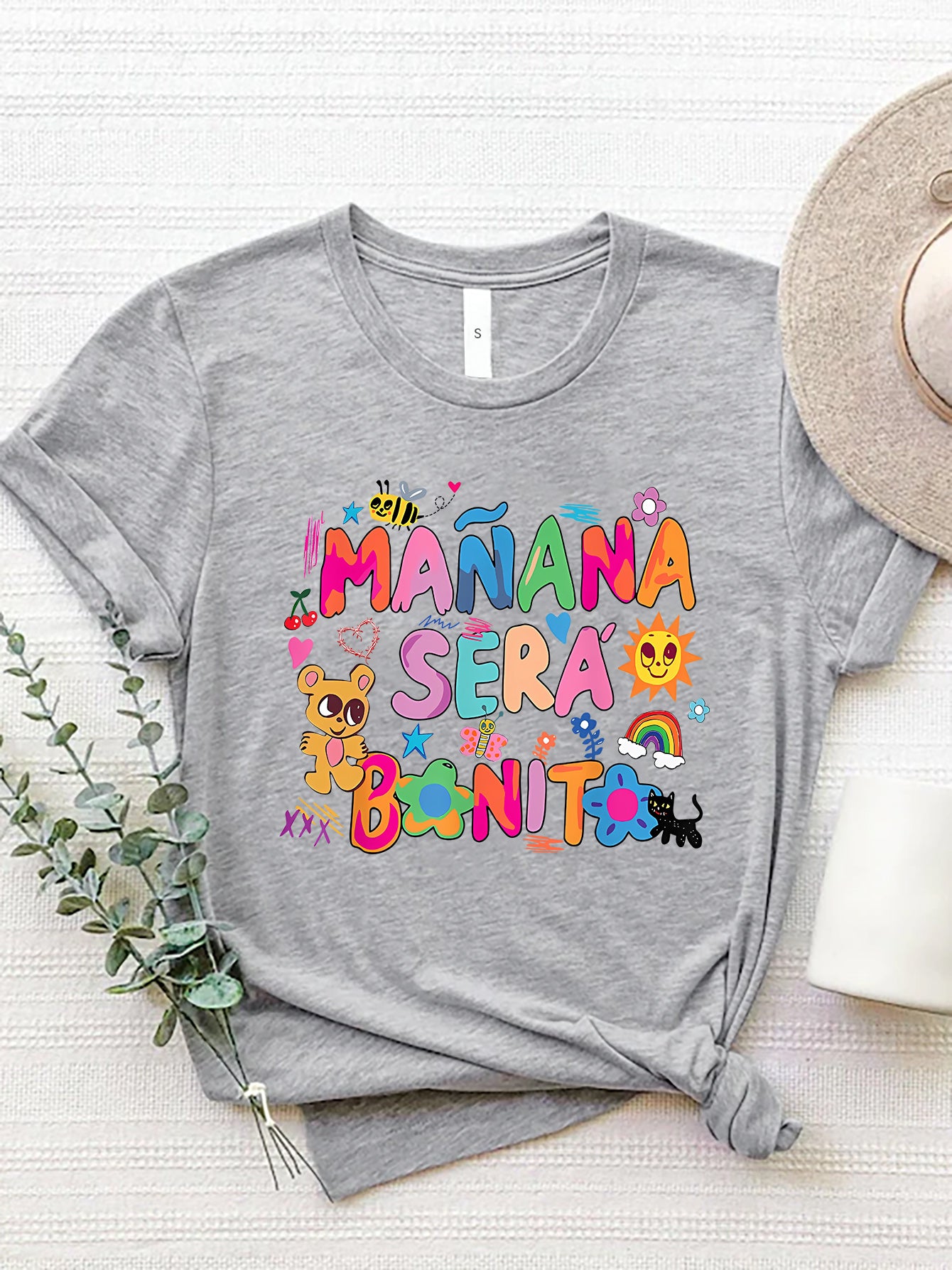 Gray graphic tee with "Mañana Sera Bonito" text and colorful cartoon illustrations.