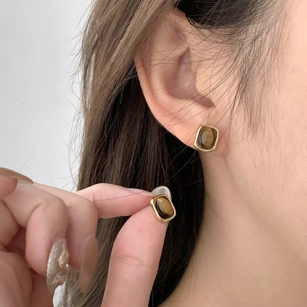 Gold color square stud earrings with polished tiger eye stone detail