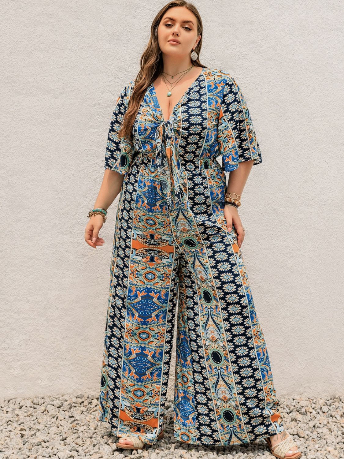 Bohemian palazzo jumpsuit in Peacock Blue with tie-front and bell sleeves.