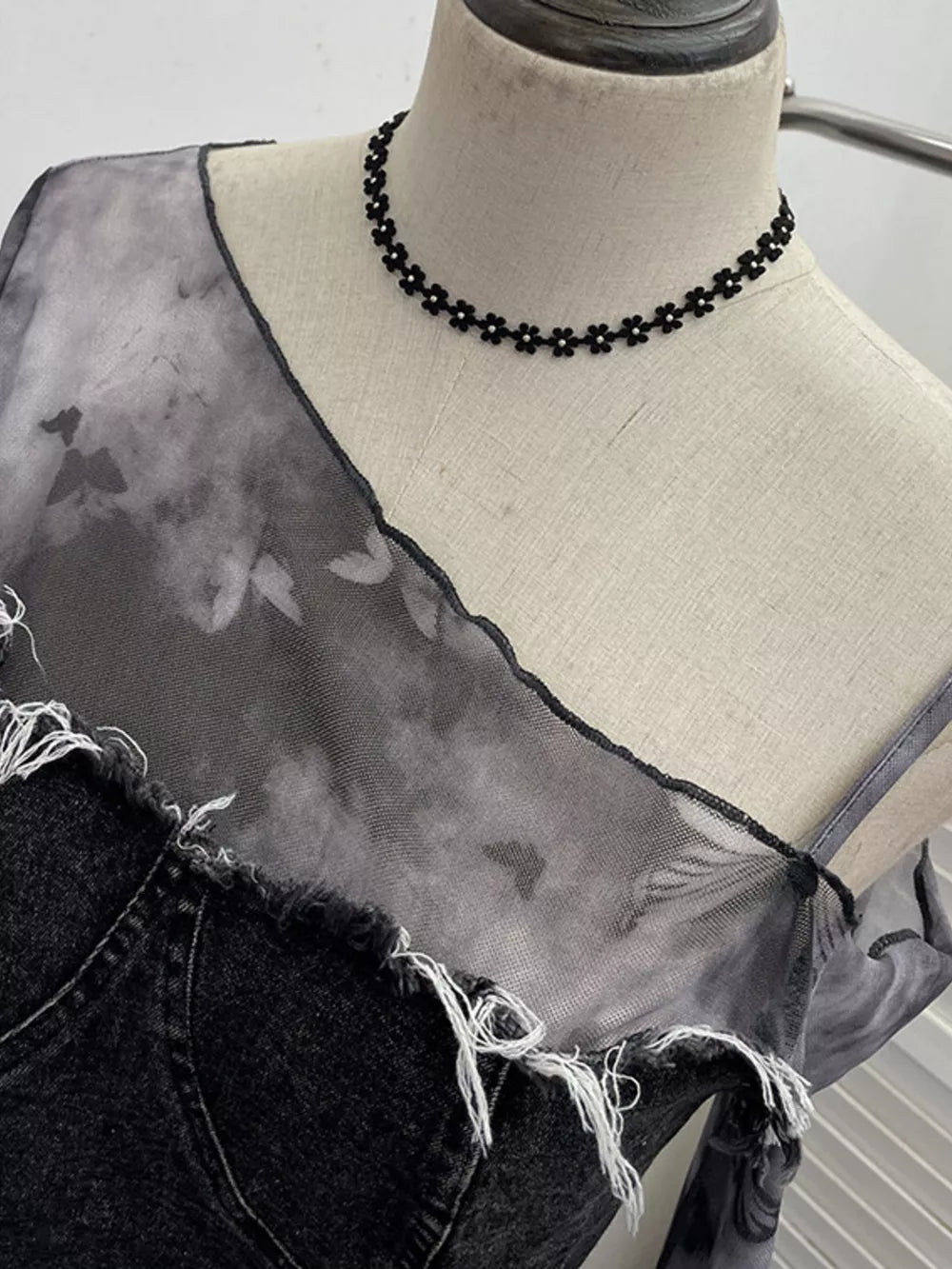 Edgy asymmetrical t-shirt in gray black with distressed denim and sheer butterfly print overlay.
