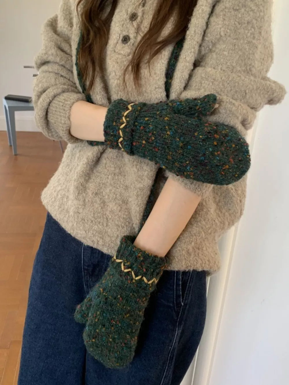 Textured green knit mittens with zig-zag detail and flecks of color