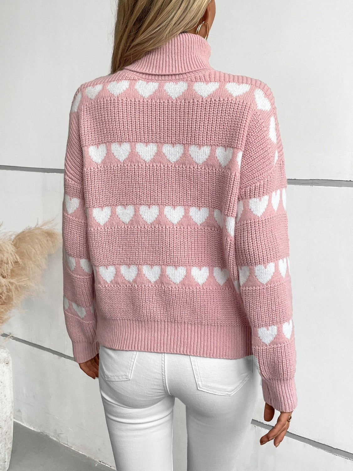 Pink turtleneck sweater with white heart intarsia pattern, acrylic knit.