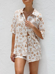 Tan and white resort set with beach graphic print, button-up short sleeve shirt and shorts.