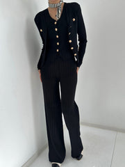 Black ribbed knit outfit set with gold buttons, featuring a cardigan and wide-leg pants.