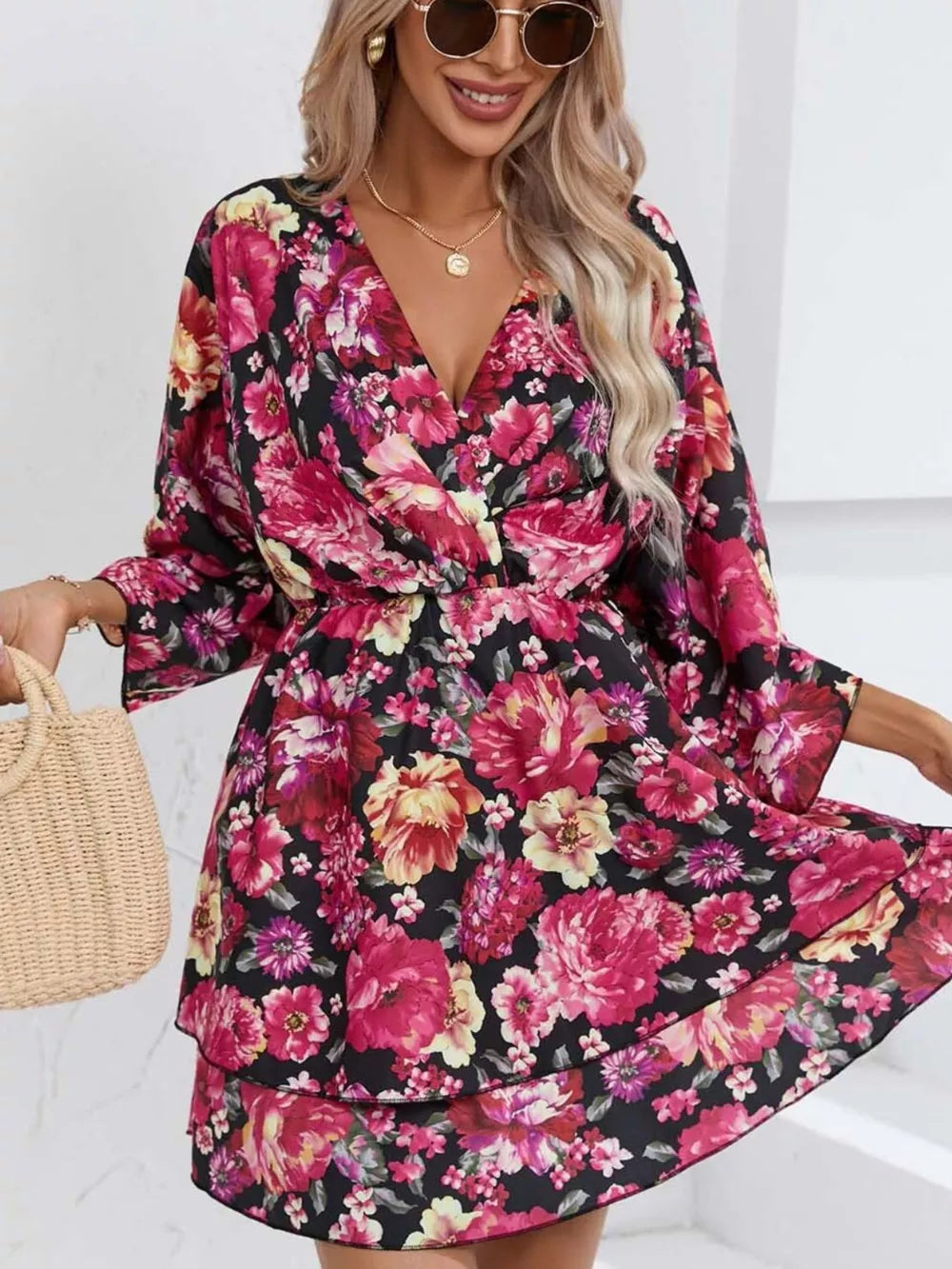 Floral ruffle hem mini dress in black with pink and yellow flowers, V-neck, and flowy sleeves.