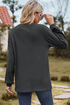 Dark Gray waffle knit raglan sleeve top with eyelet detail on sleeves.