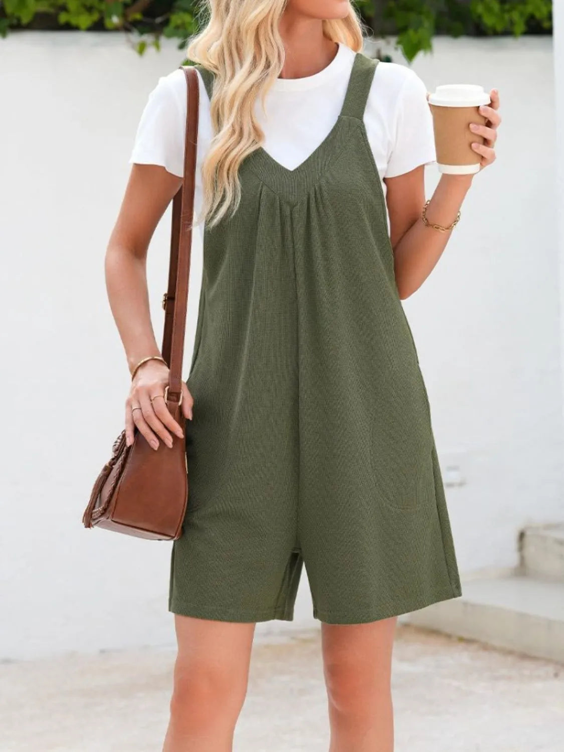 Moss green textured romper with gathered yoke and pockets, styled with a white tee.