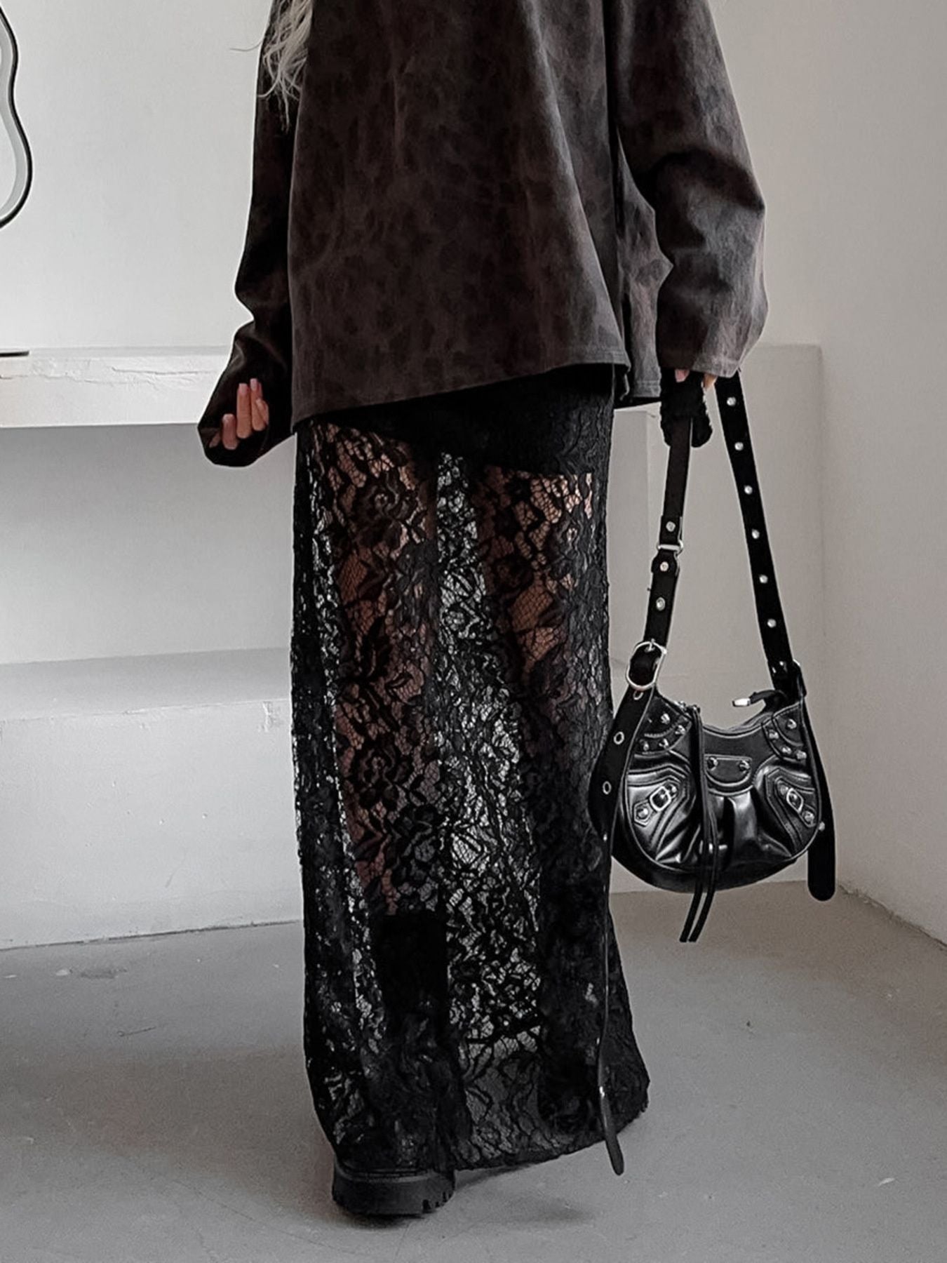 Black lace maxi skirt with sheer detail, featuring a floral pattern and floor-length cut.