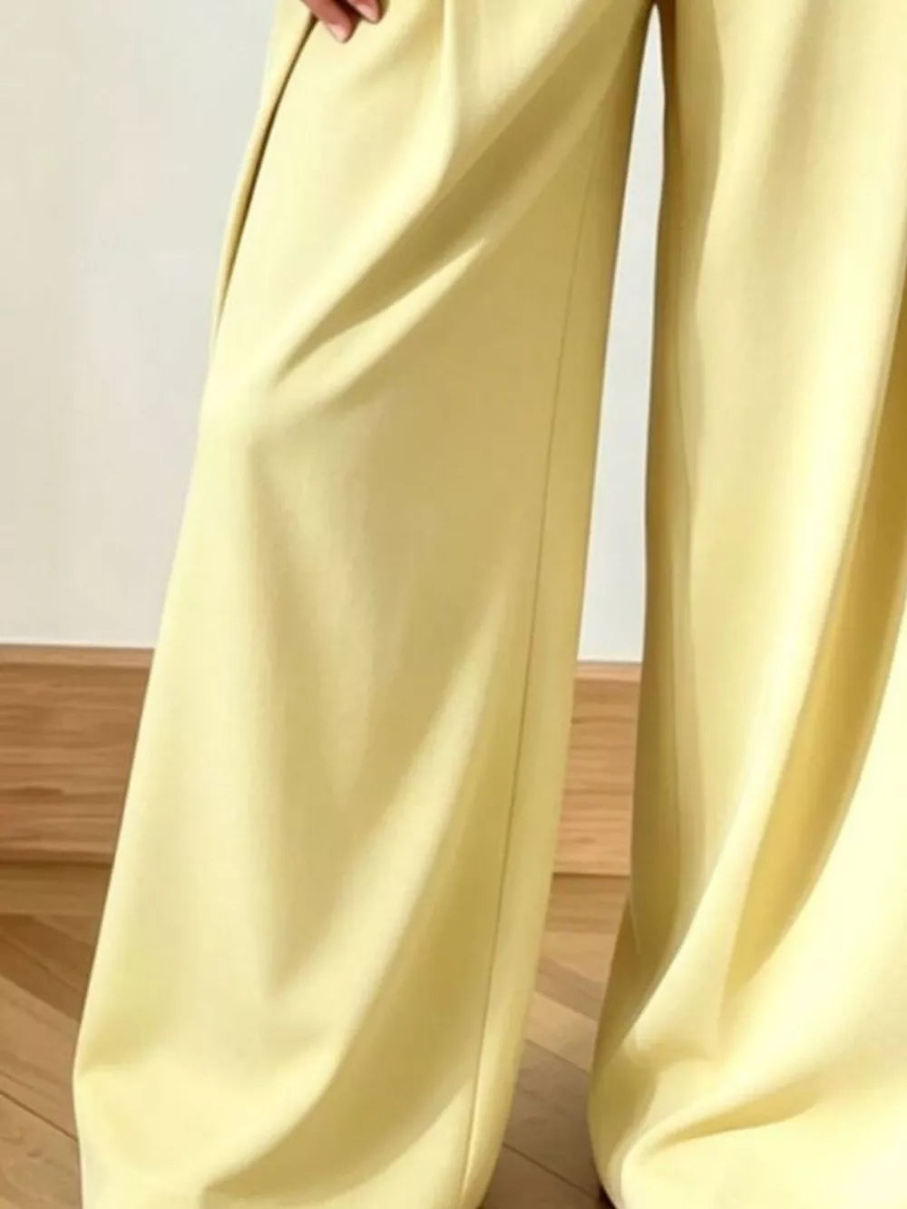 Yellow wide-leg pants with a flowing cut and subtle pleats.