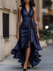 Navy blue satin high-low ruffled maxi dress with a cinched waist and halter neckline.