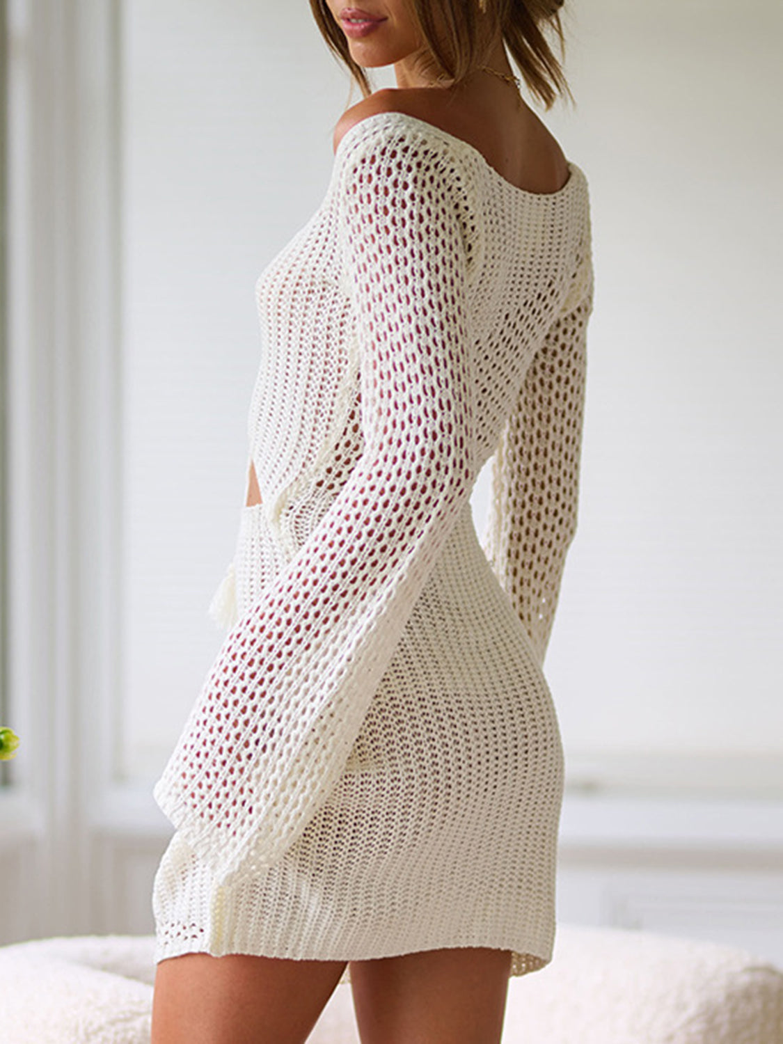 Crochet lace-up cutout mini dress in cream with long sleeves and a sheer knit pattern.