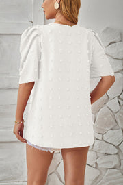 White textured puff-sleeve blouse with pom-pom details and a relaxed fit.
