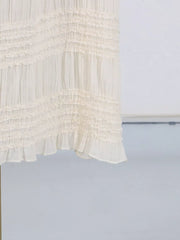 Textured cream halter neck maxi maternity swim dress with tiered ruffles.