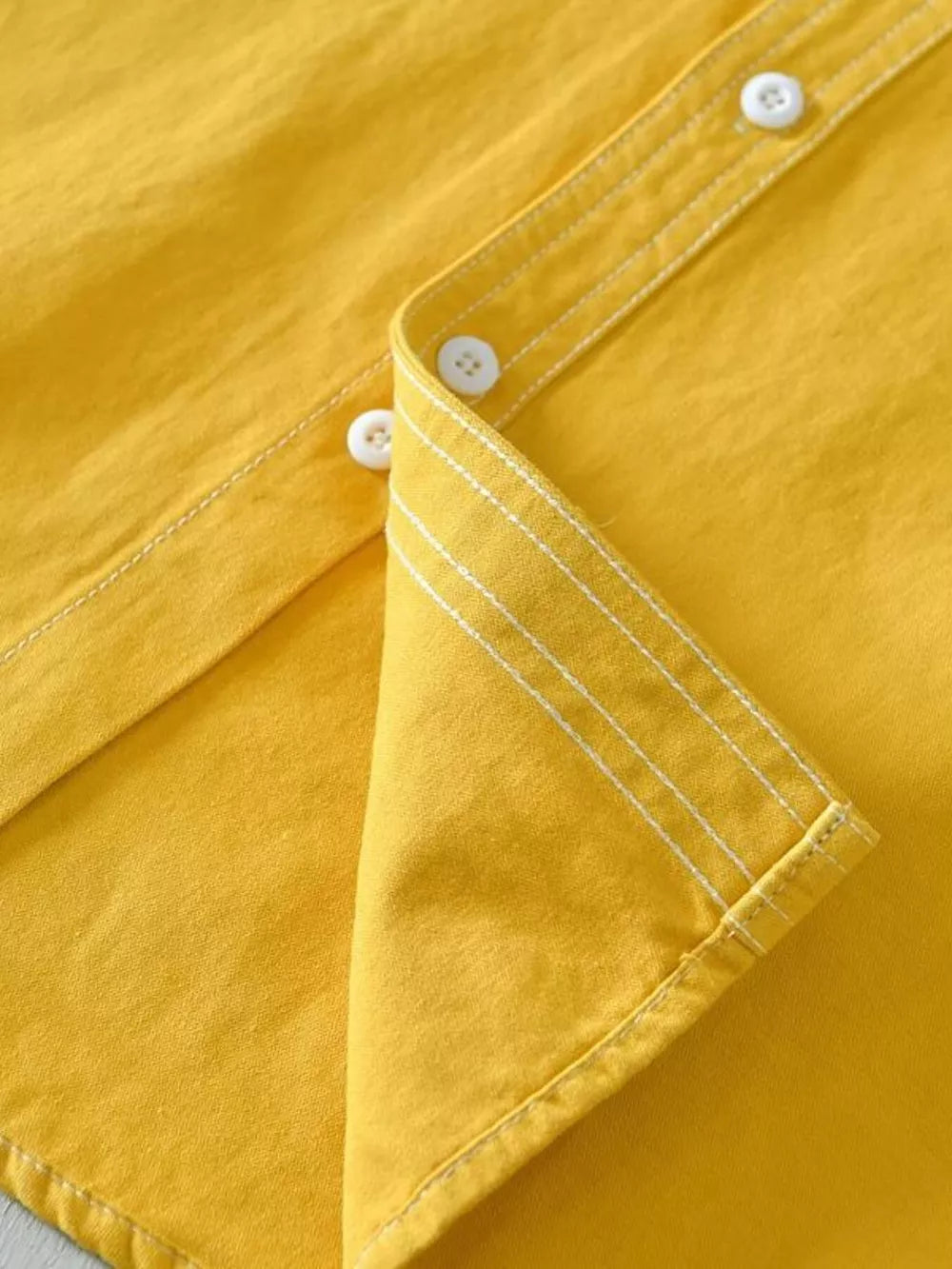 Yellow men's button-up shirt with contrast stitching and white buttons