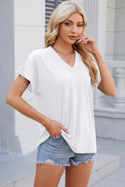 White dolman sleeve slouchy v-neck top with short sleeves and a relaxed fit.