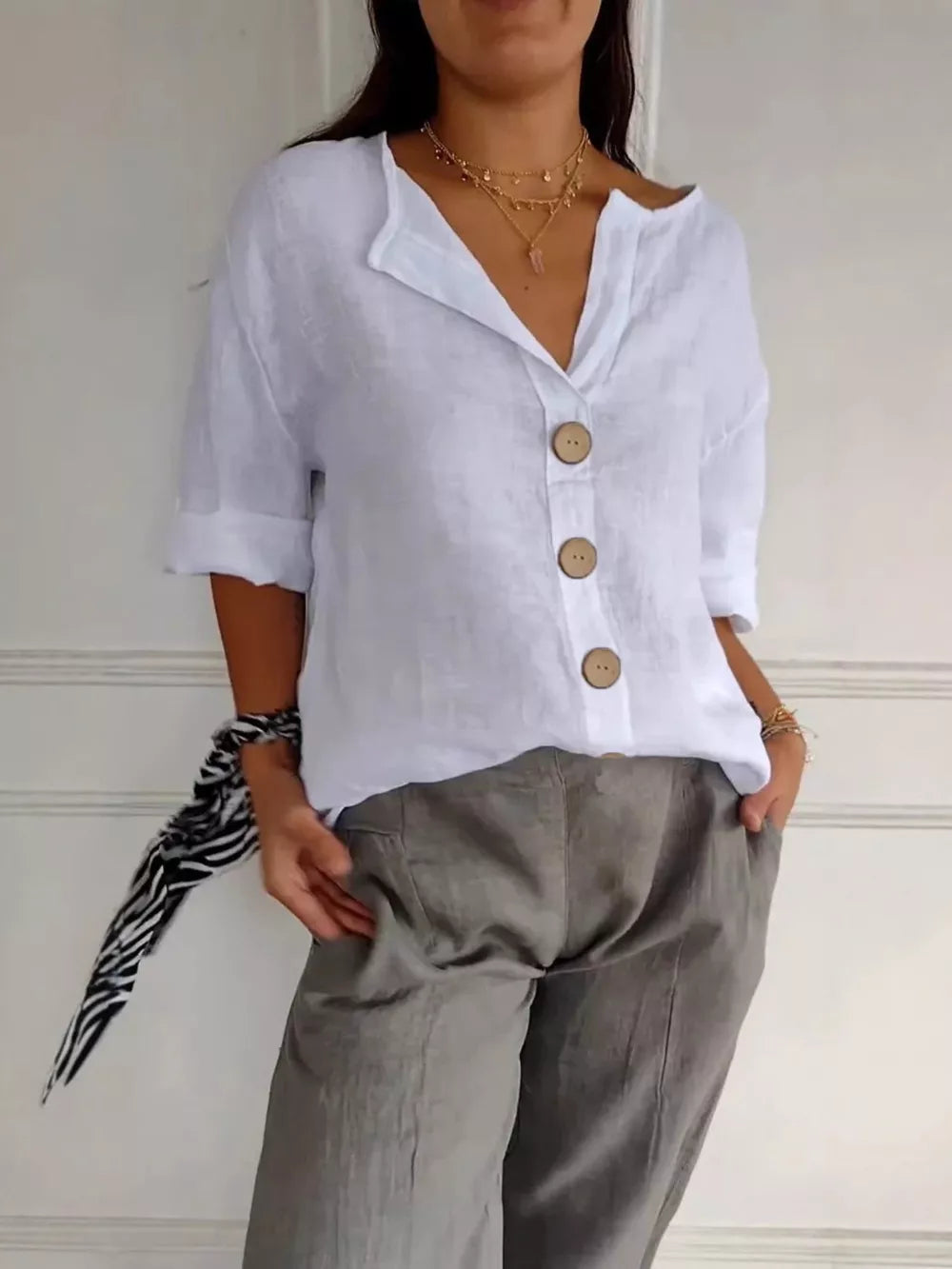 White linen button-down shirt with relaxed fit and wooden buttons.