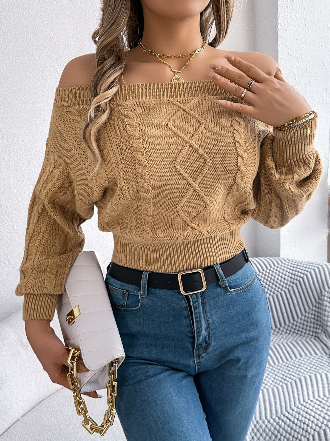 Camel cable knit off-shoulder crop sweater with diamond pattern detail.