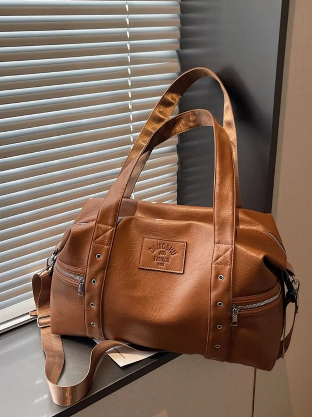 Chic brown pu leather shoulder bag with adjustable strap and zippered pockets.