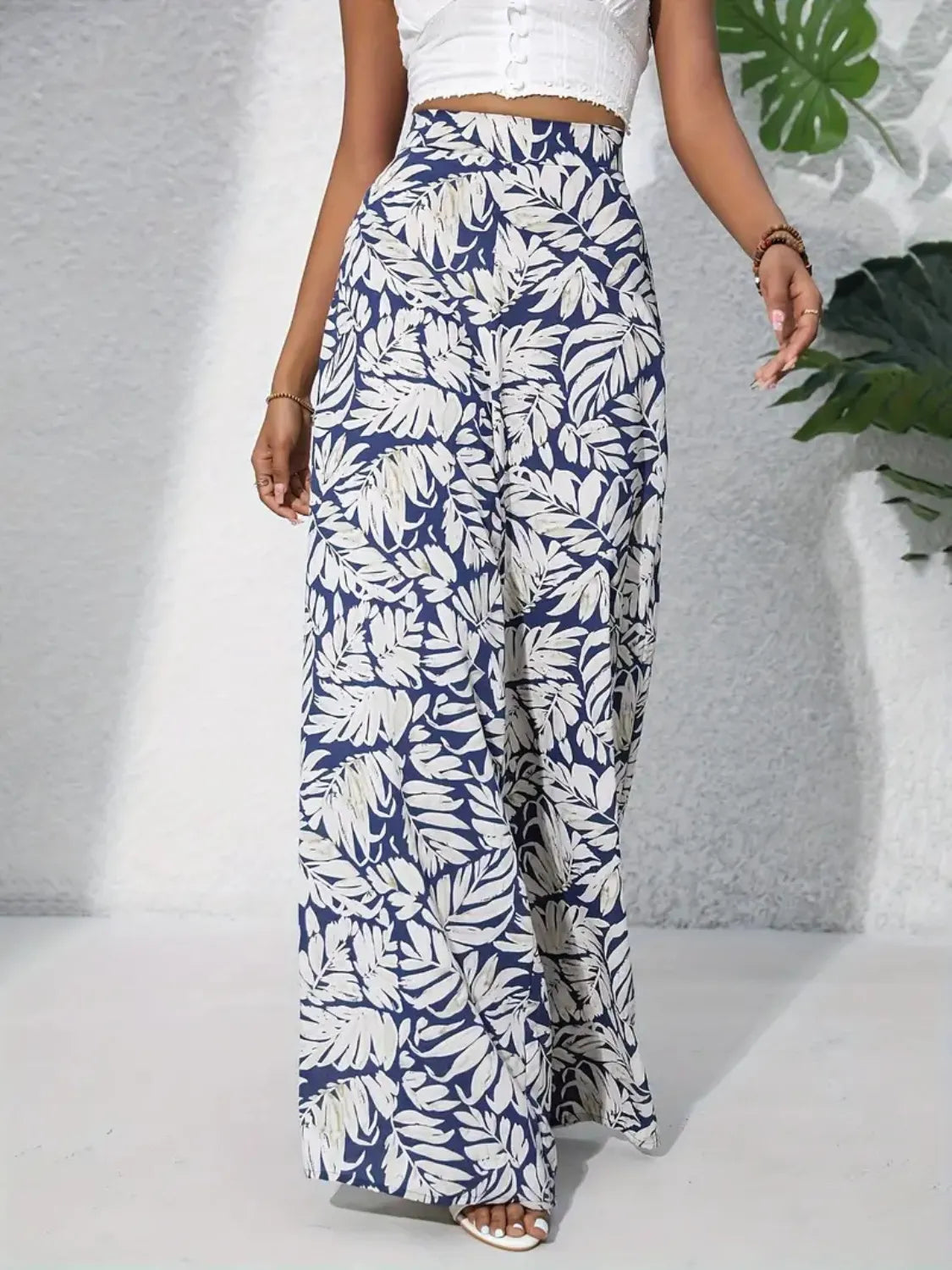 Palazzo trousers in blue with white tropical leaf print, 100% polyester, wide leg.
