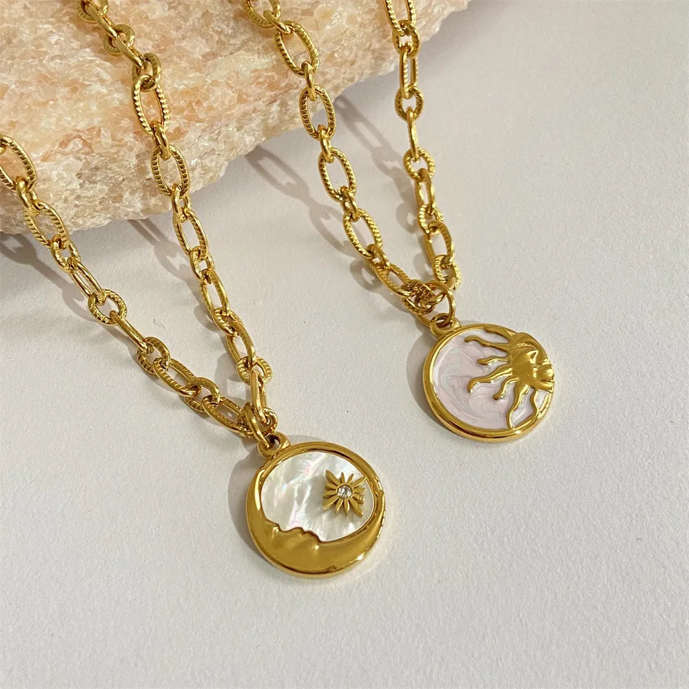 Gold chain necklaces with sun and moon medallions, one with a star detail.