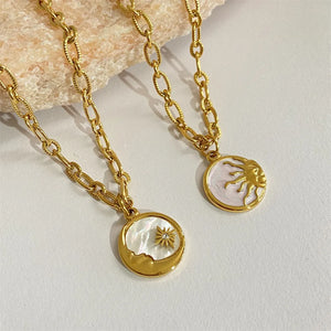 Gold chain necklaces with sun and moon medallions, one with a star detail.