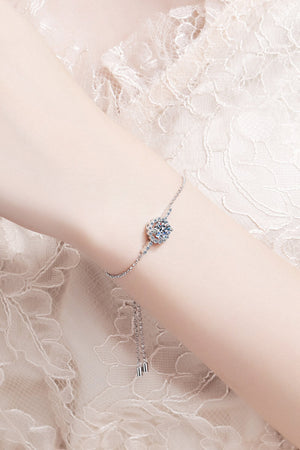Silver adjustable bracelet with a sparkling floral-shaped cubic zirconia center stone.