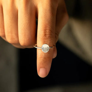Silver ring with engraved wave pattern on a round face, casual band style