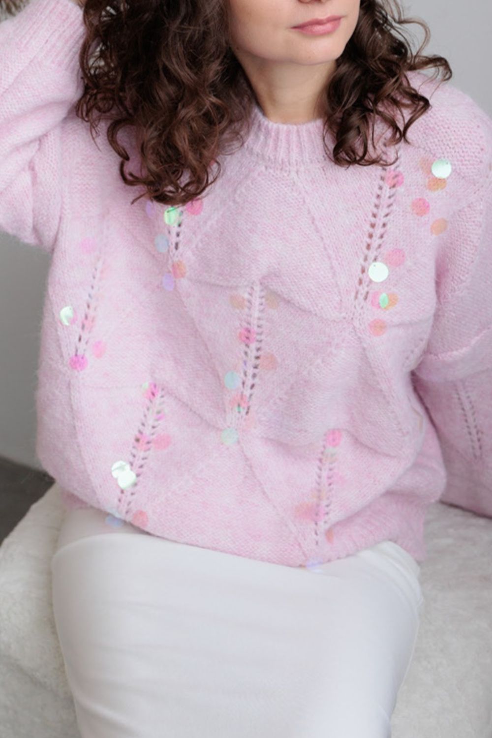 Blush pink diamond knit sweater with scattered iridescent sequins and open knit details.