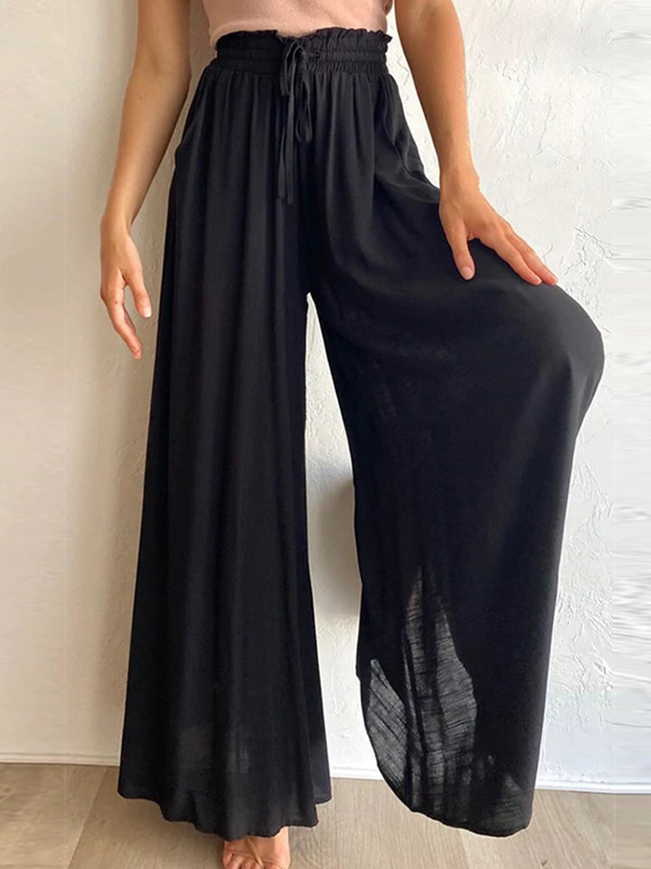 Black gathered waist palazzo pants with a drawstring and wide legs.