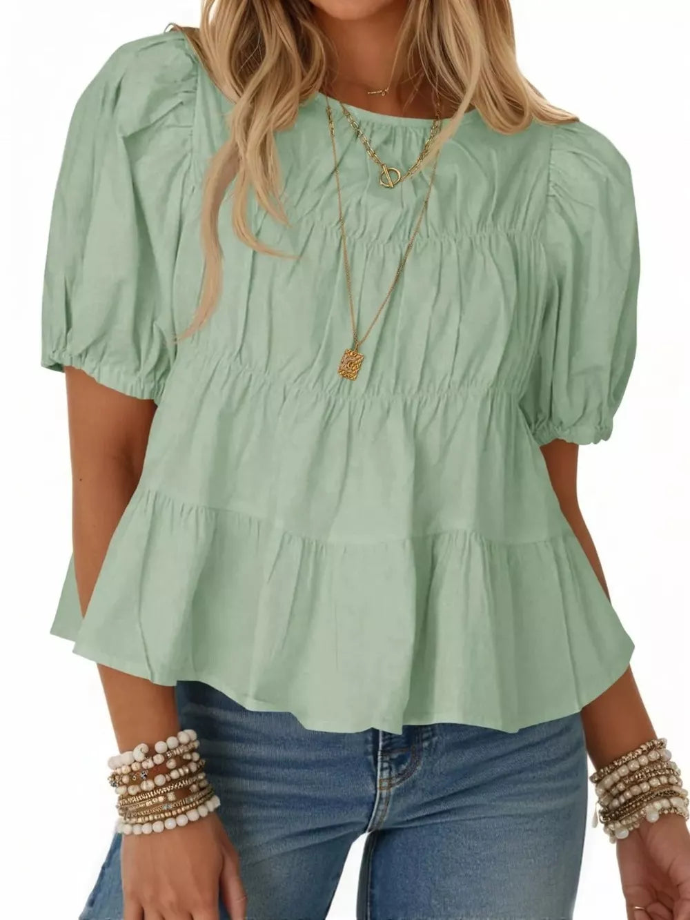 Light green maternity blouse with puff sleeves, ruffled tiers, and smocked bodice detail.