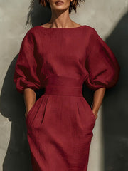 Wine red midi dress with boat neck, puff sleeves, and pockets.