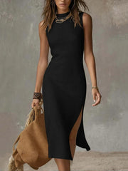 Black sleeveless midi dress with high neckline and side slit, worn with layered necklaces.