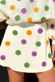 Polka dot crop top and mini skirt set with purple, green, and orange dots on ivory fabric.