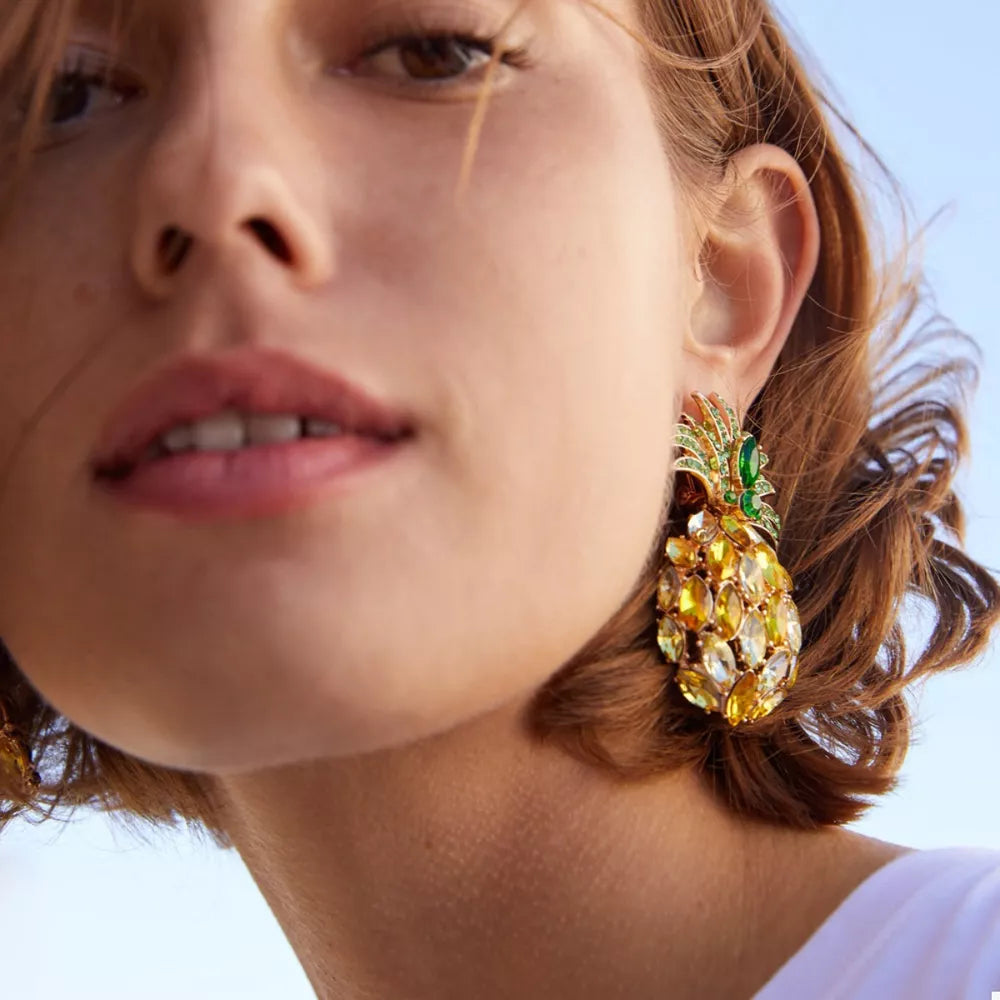 Pineapple-inspired dangle earrings with yellow and green rhinestones.