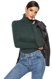 Dark green ribbed turtleneck bodysuit with long sleeves, styled with blue jeans and a leather jacket.