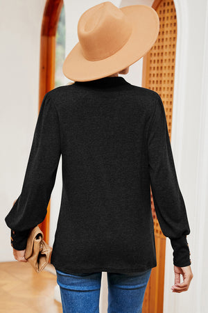 Black buttoned blouse with puff sleeves and button cuffs, casual long sleeve top.