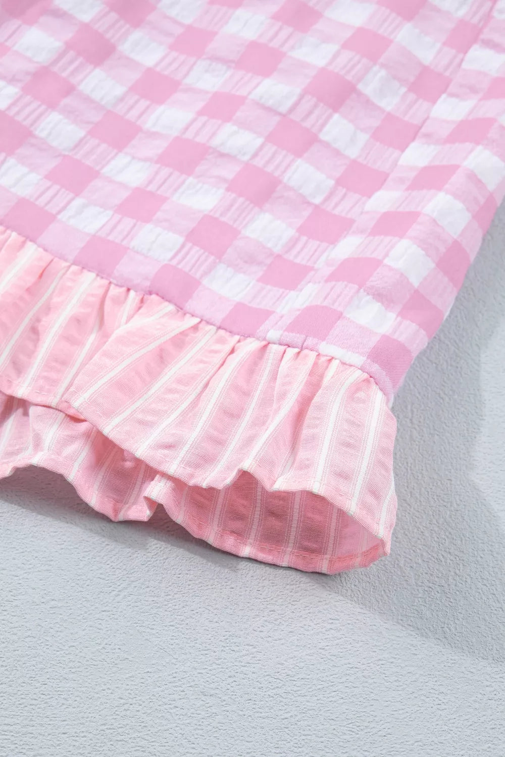 Charming gingham ruffle hemmed shorts in blush pink with striped ruffle detail.
