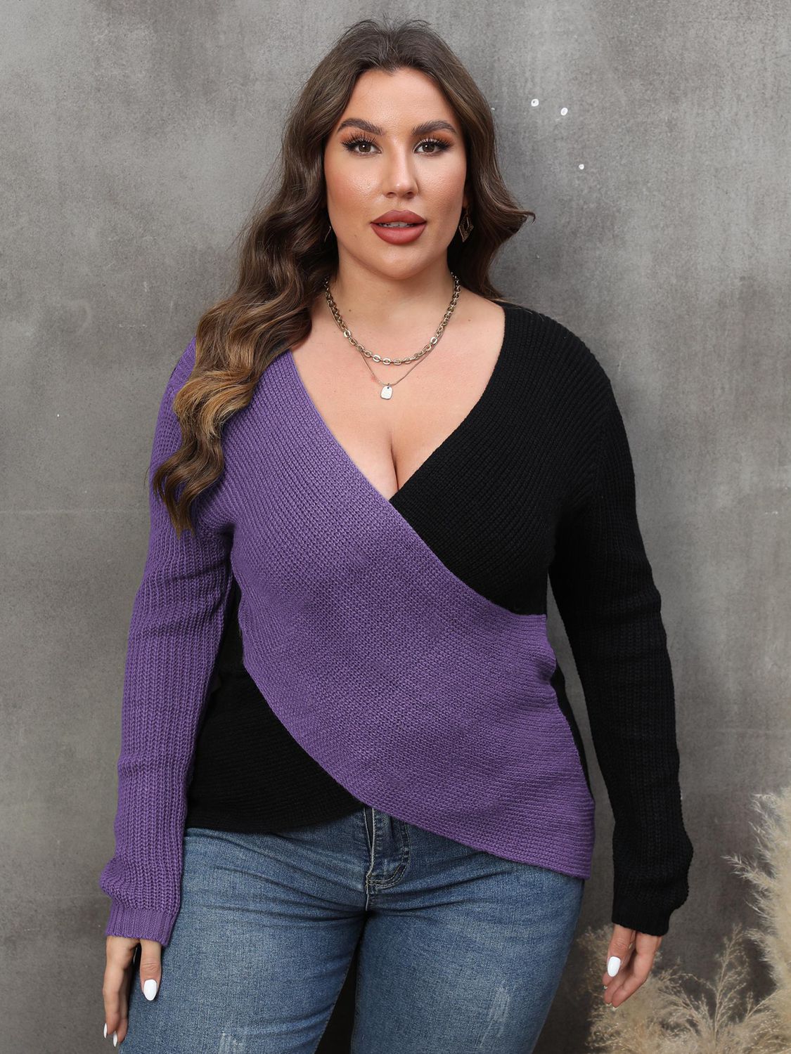 Colorblock crossover knit sweater in violet and black with a deep V-neck.