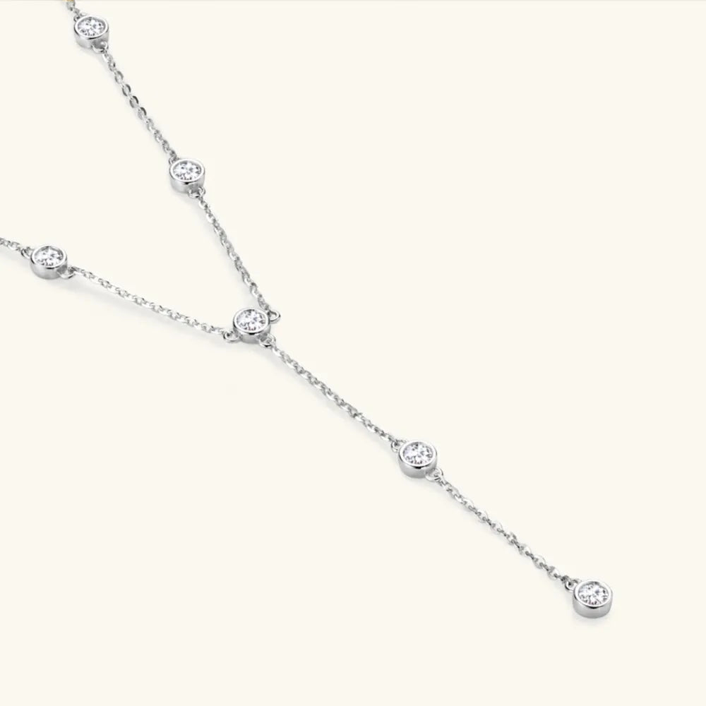 Silver lariat necklace with bezel-set moissanite diamonds on a delicate chain