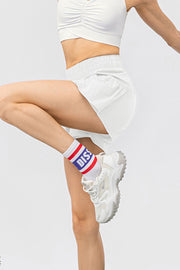 White active shorts with gathered elastic waistband and side pockets.