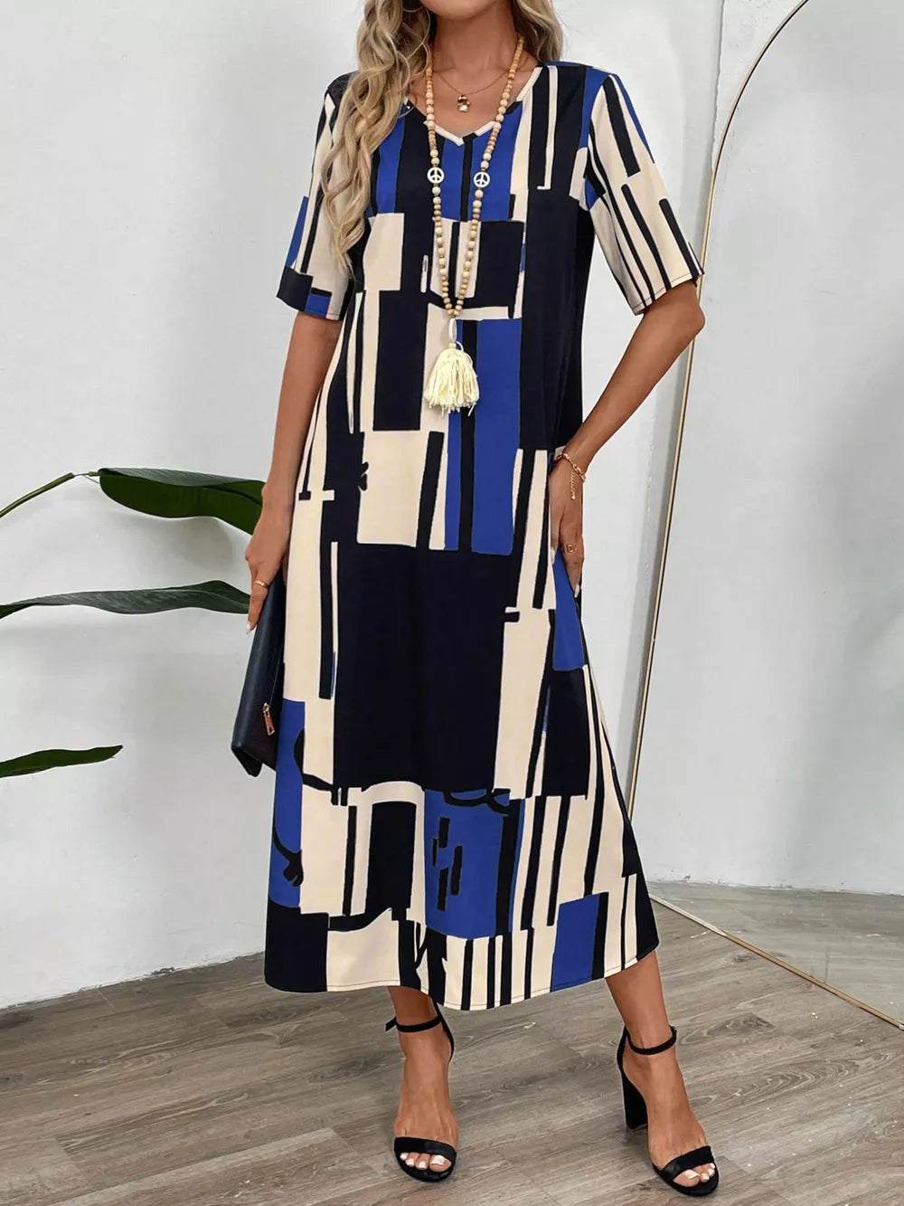 Geometric V-neck midi dress in dark blue with abstract block print, short sleeves, and a relaxed fit.