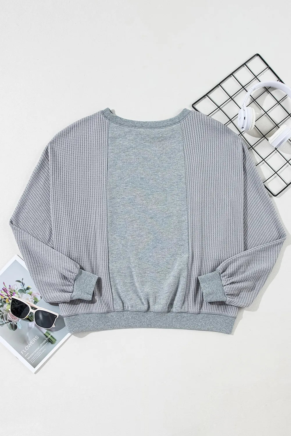 Gray waffle knit top with contrasting gray panels and balloon sleeves.