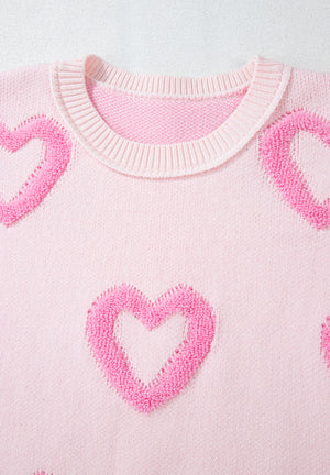 Pink knit sweater with fuzzy heart appliques and balloon sleeves.