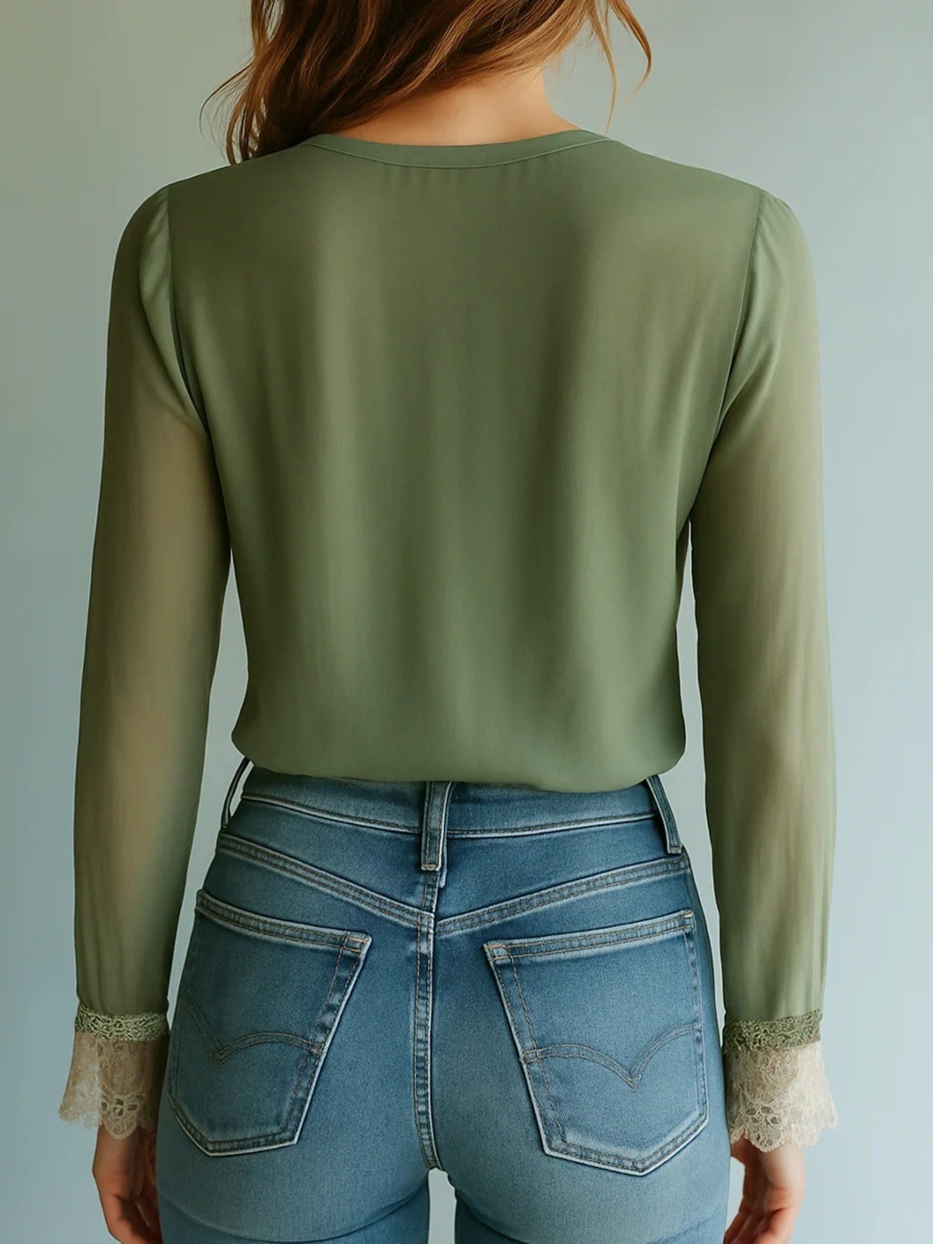 Olive green blouse with sheer bishop sleeves and lace cuffs, paired with blue jeans.
