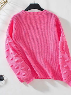 Hot pink knit sweater with textured bobble sleeves and crew neck.