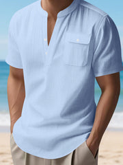 Light blue short sleeve henley shirt with band collar and chest pocket.